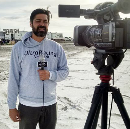 Video journalist reporting at the Salt Flats 100 ultramarathon in Utah, conducting on-location coverage with professional camera equipment in the Bonneville Salt Flats.